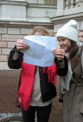 two people holding a map and smiling while on the Quen of Schwabylon City Puzzle Hunt